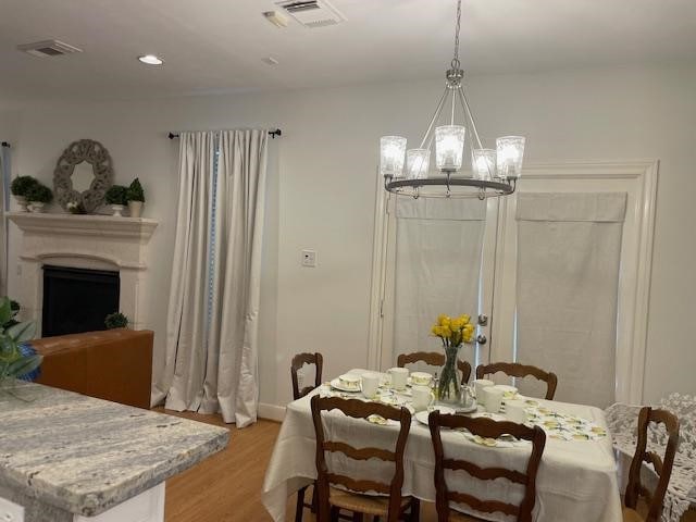 1615 Lakeside Enclave Dr, Houston, TX 77077 - dining area with a chandelier, light wood finished floors, a fireplace, baseboards, and recessed lighting