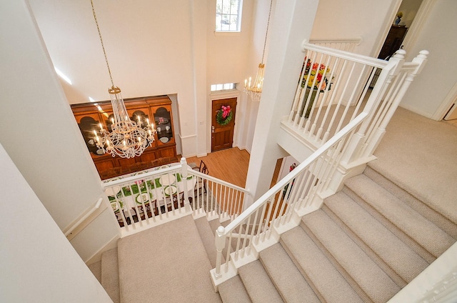 1615 Lakeside Enclave Dr, Houston, TX 77077 - stairway with a chandelier, a high ceiling, wood finished floors, and carpet flooring