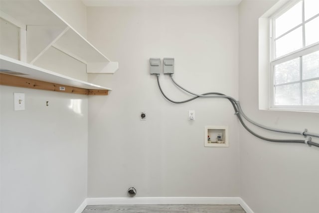 washroom with baseboards, a healthy amount of sunlight, washer hookup, and laundry area