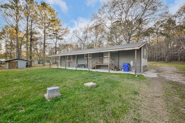 back of house with an outdoor structure, a shed, stairs, and a yard