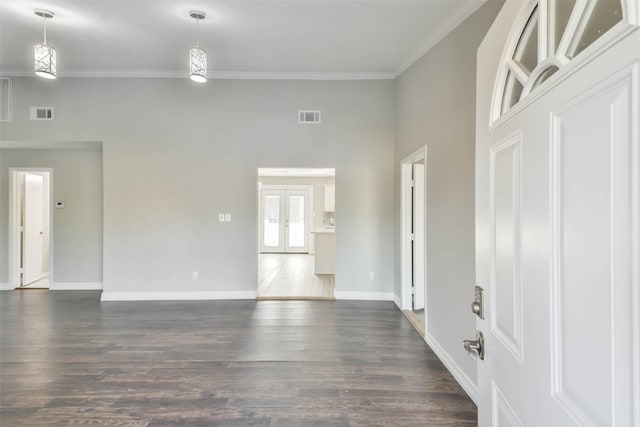 interior space featuring crown molding, visible vents, baseboards, dark wood-style flooring, and a towering ceiling