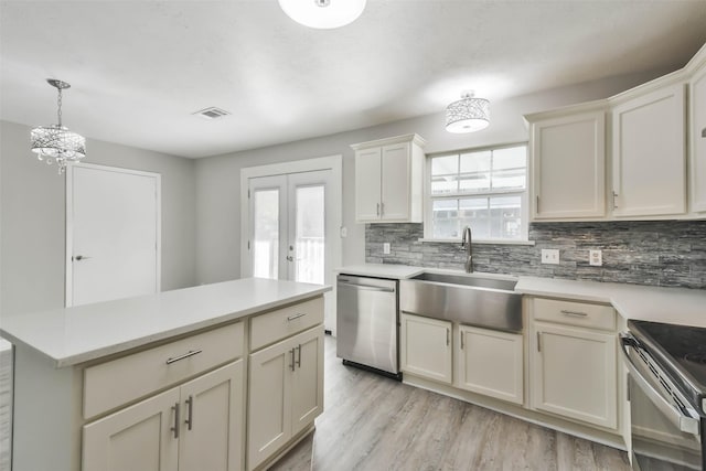 kitchen with appliances with stainless steel finishes, visible vents, light countertops, and a sink