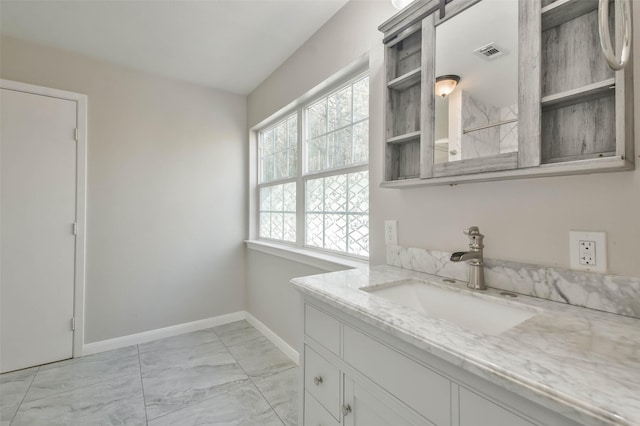 bathroom with visible vents, vanity, marble finish floor, and baseboards
