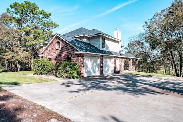 view of side of home featuring a chimney, a yard, brick siding, concrete driveway, and an attached garage