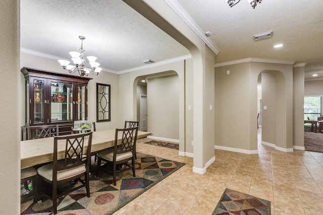 dining room featuring a textured ceiling, visible vents, and arched walkways