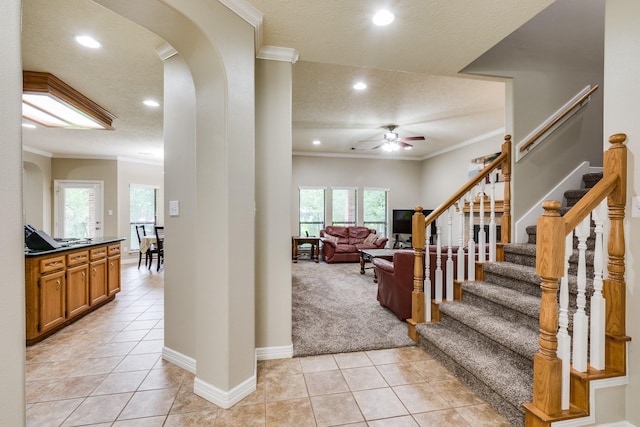 foyer featuring recessed lighting, arched walkways, light tile patterned floors, ornamental molding, and ceiling fan