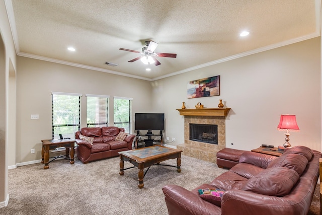 living room featuring a tiled fireplace, a ceiling fan, visible vents, carpet, and a textured ceiling
