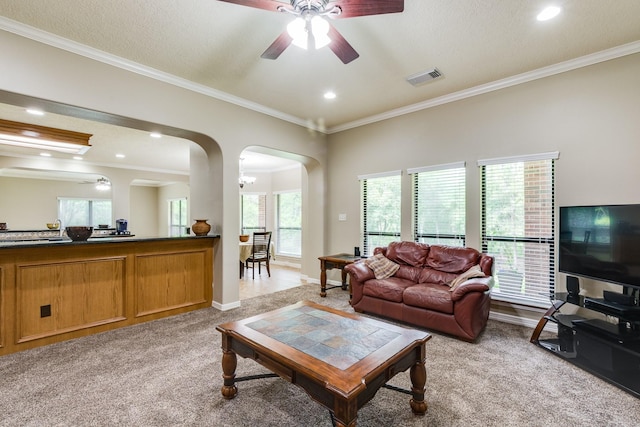 living area featuring crown molding, visible vents, arched walkways, light carpet, and a ceiling fan
