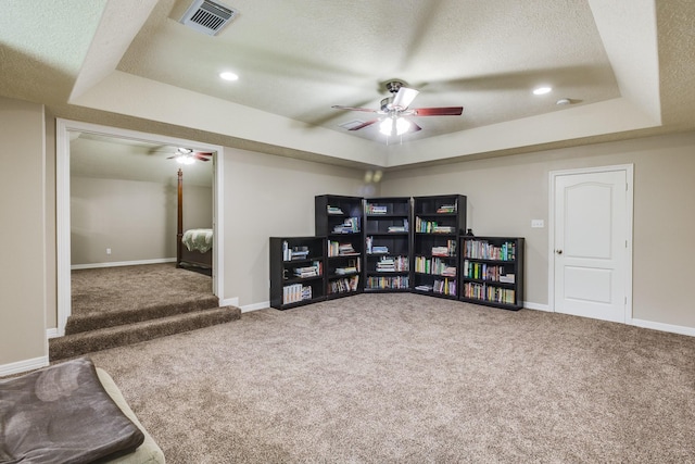 playroom with a raised ceiling, a ceiling fan, and visible vents