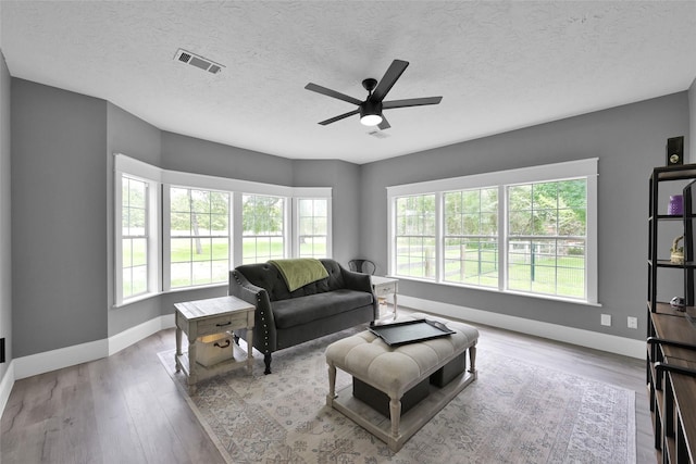 31235 Edgewater Dr, Magnolia, TX 77354 - living room with baseboards, healthy amount of natural light, a ceiling fan, and a textured ceiling