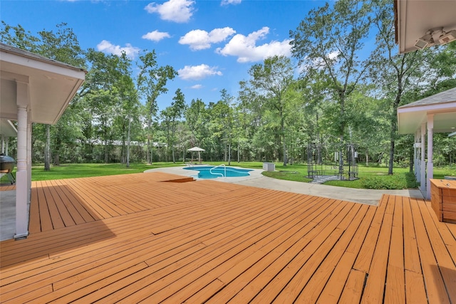 31235 Edgewater Dr, Magnolia, TX 77354 - wooden deck featuring view of scattered trees, a yard, and an outdoor pool