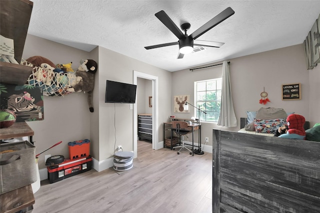 31235 Edgewater Dr, Magnolia, TX 77354 - bedroom featuring light wood-style floors, baseboards, a textured ceiling, and ceiling fan