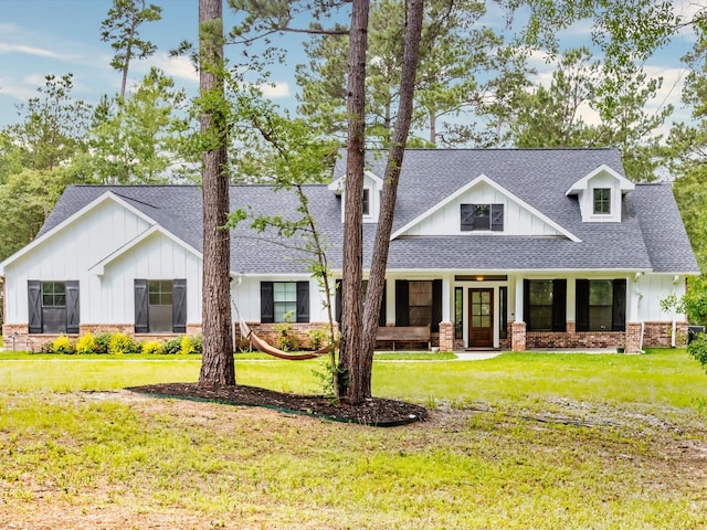 165 Sanctuary Rd, Huntsville, TX 77340 - view of front of property with board and batten siding, covered porch, a shingled roof, stone siding, and a front yard