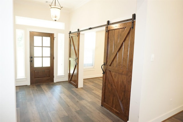 165 Sanctuary Rd, Huntsville, TX 77340 - foyer featuring dark wood finished floors, a barn door, ornamental molding, and baseboards
