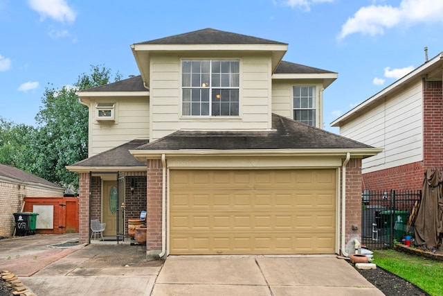 view of front of property featuring brick siding, fence, and concrete driveway