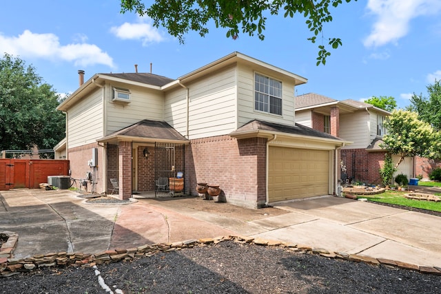 view of front of house with fence, cooling unit, an attached garage, and brick siding