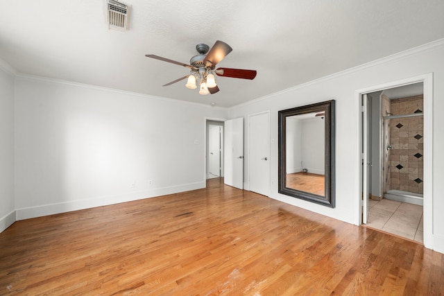 unfurnished bedroom with ensuite bath, light wood-style floors, ornamental molding, baseboards, and visible vents