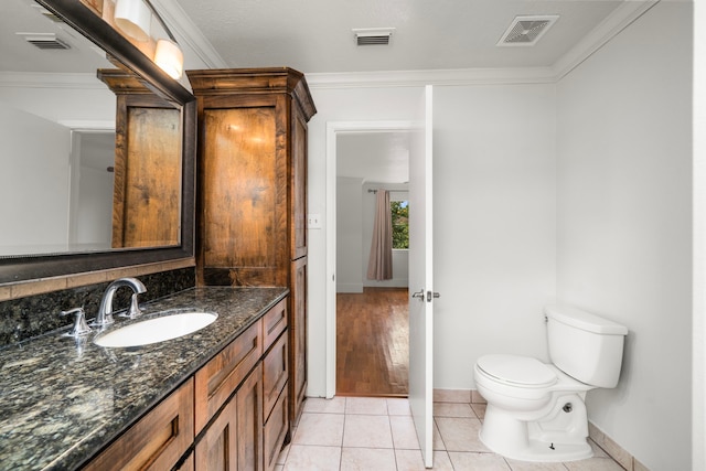 half bathroom featuring toilet, crown molding, tile patterned flooring, and visible vents