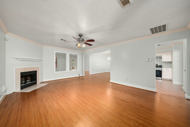 unfurnished living room with visible vents, light wood-type flooring, a ceiling fan, and crown molding