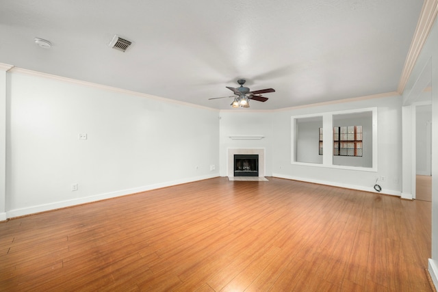unfurnished living room with visible vents, a ceiling fan, a fireplace with flush hearth, and crown molding