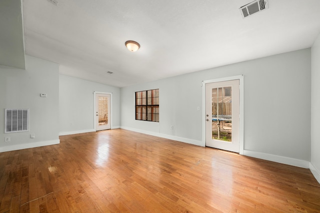 unfurnished living room with visible vents, light wood-style flooring, and plenty of natural light