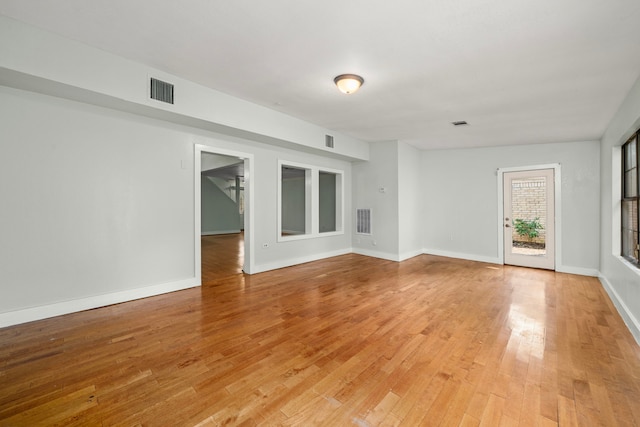 unfurnished room featuring visible vents, light wood-style flooring, and baseboards