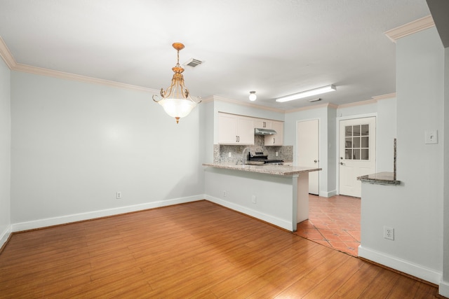 kitchen featuring light wood-style flooring, stainless steel range oven, white cabinets, backsplash, and a peninsula