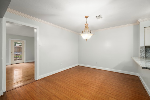 unfurnished dining area featuring crown molding, visible vents, baseboards, and light wood-type flooring