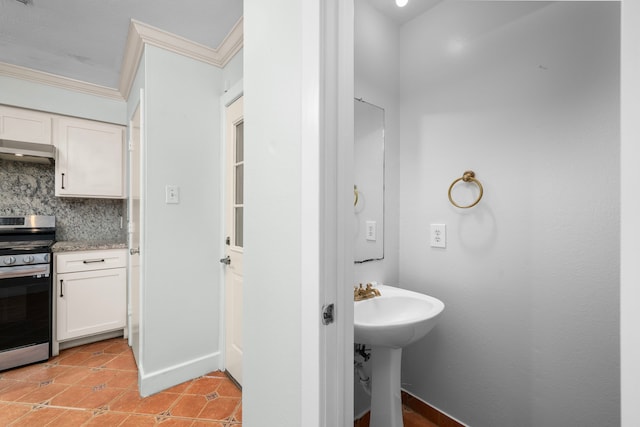 bathroom featuring ornamental molding, a sink, backsplash, and tile patterned floors