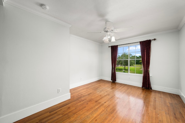 spare room featuring crown molding, a ceiling fan, baseboards, and light wood-style floors