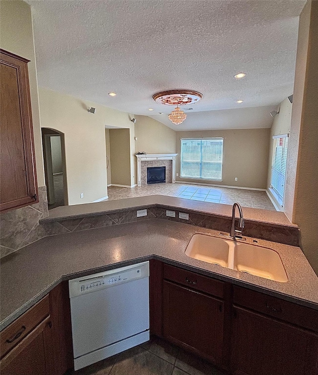 kitchen with a sink, white dishwasher, dark countertops, a textured ceiling, and open floor plan