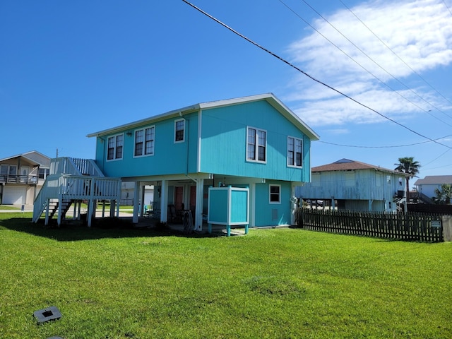 16606 John Davis Rd, Jamaica Beach, TX 77554 - rear view of property with fence, a wooden deck, stairs, and a lawn