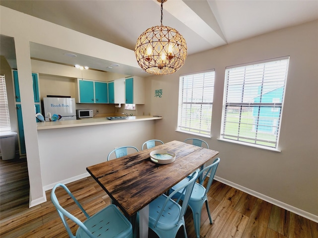 16606 John Davis Rd, Jamaica Beach, TX 77554 - dining room featuring a chandelier, baseboards, wood finished floors, and vaulted ceiling