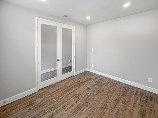 unfurnished room with recessed lighting, wood finished floors, baseboards, visible vents, and french doors
