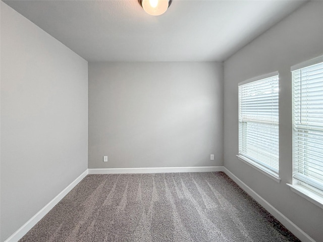 unfurnished room featuring baseboards and carpet flooring