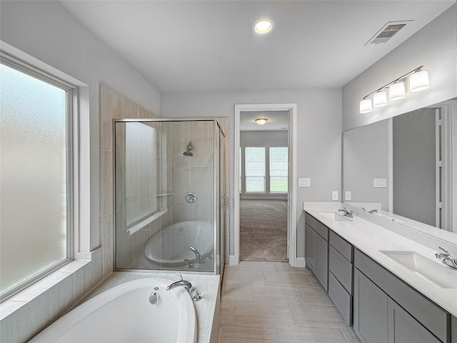 full bath featuring visible vents, a bath, a stall shower, and a sink