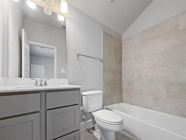 bathroom featuring vanity, toilet, a textured wall, shower / washtub combination, and lofted ceiling