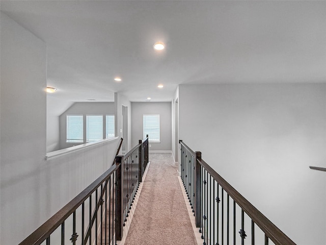 hall featuring recessed lighting, baseboards, and light carpet