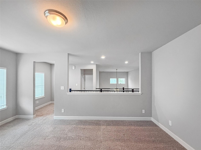 carpeted spare room featuring recessed lighting and baseboards