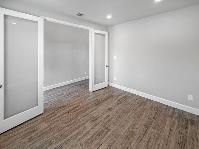 basement with baseboards, visible vents, dark wood-type flooring, and recessed lighting