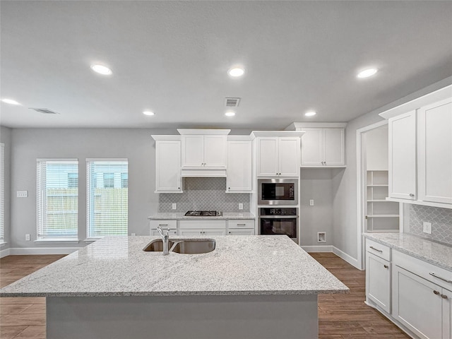 kitchen featuring visible vents, white cabinets, and a sink