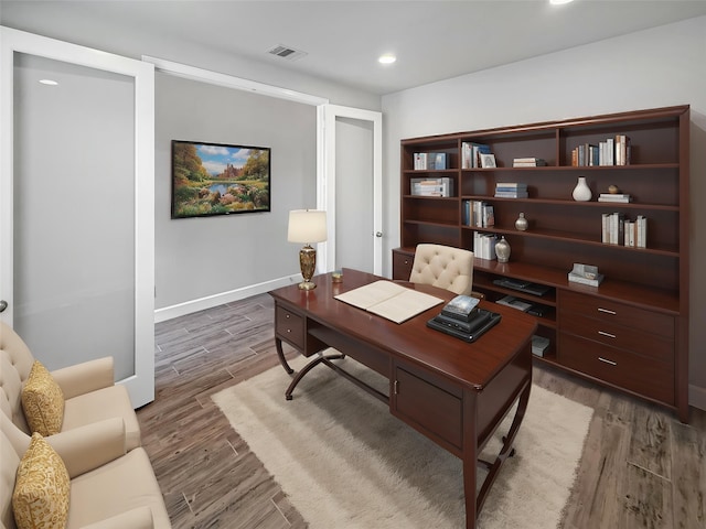 home office with recessed lighting, visible vents, baseboards, and light wood-type flooring