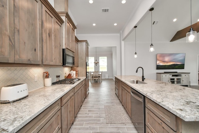 kitchen with a sink, stainless steel appliances, crown molding, visible vents, and backsplash