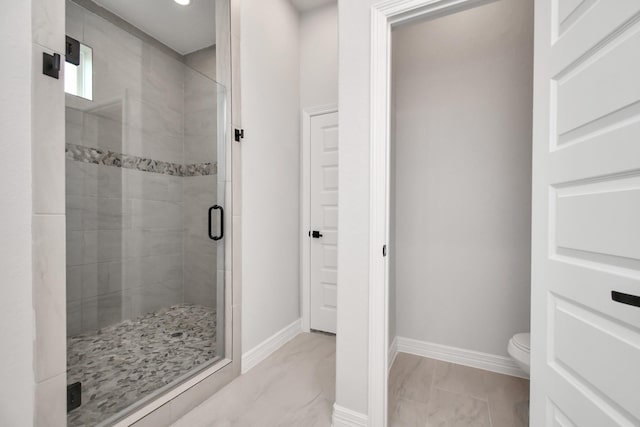 full bath with toilet, marble finish floor, a shower stall, and baseboards