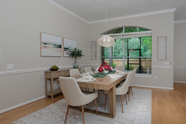 dining area with ornamental molding, wood finished floors, and baseboards