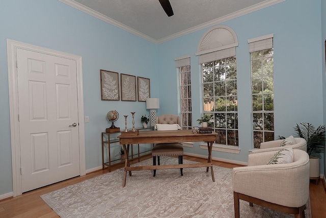 home office with ornamental molding, light wood finished floors, ceiling fan, and baseboards