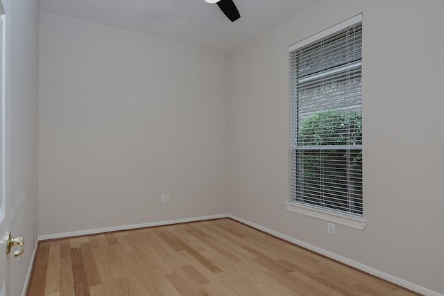empty room with wood finished floors, baseboards, and ceiling fan