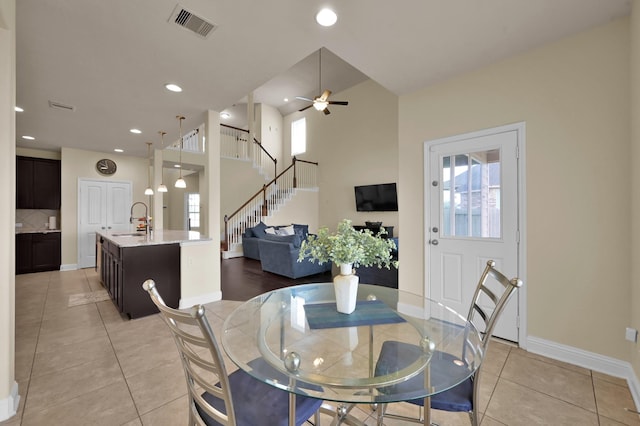 8107 Lockridge Terrace Ln, Cypress, TX 77433 - dining area featuring light tile patterned floors, visible vents, baseboards, a ceiling fan, and stairs