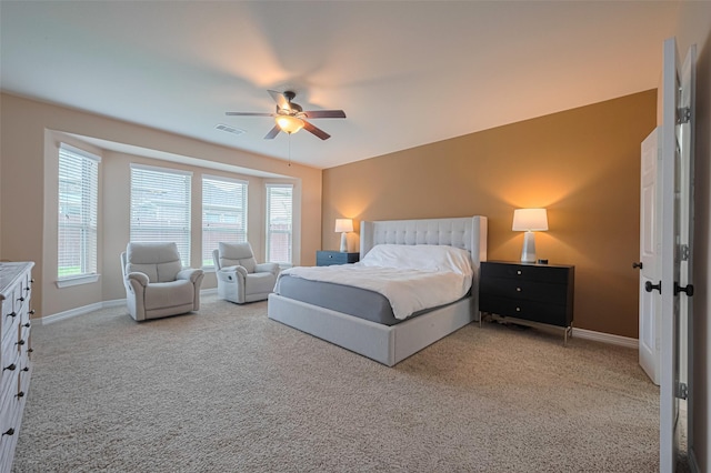 bedroom with visible vents, baseboards, and light carpet