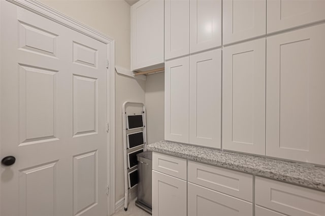 kitchen featuring white cabinetry and light stone countertops